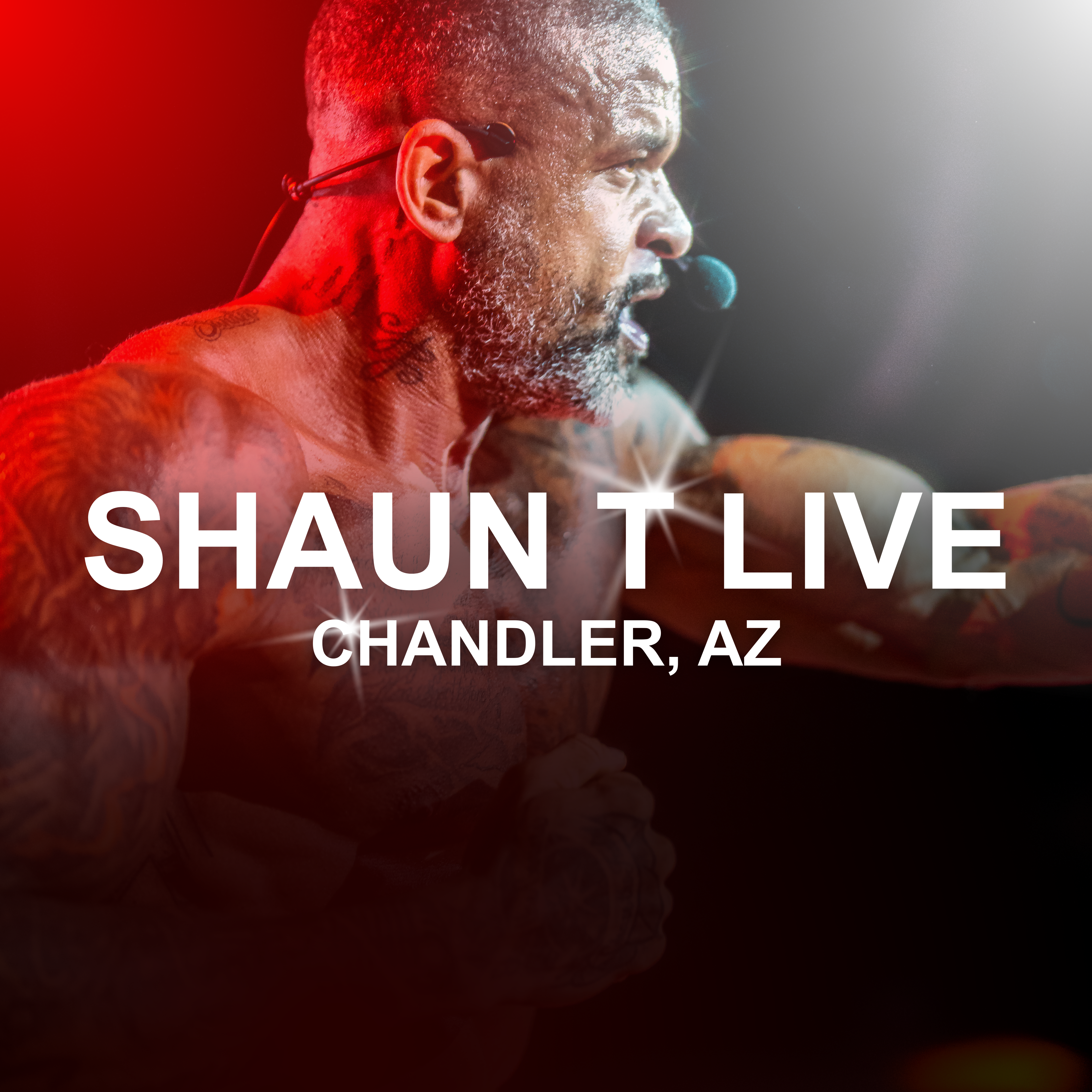 Shaun T performing live on stage, wearing a headset microphone and delivering an intense workout cue under dramatic red and white lighting. Text on the image reads: ‘SHAUN T LIVE — CHANDLER, AZ.